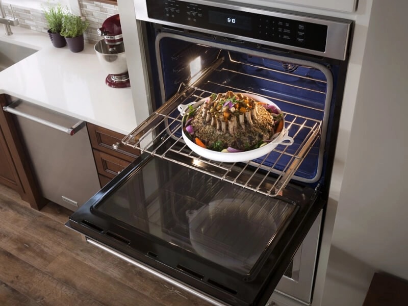 Meat and veggies in a pan on an oven rack