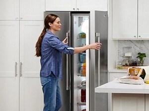 Person opening a stainless steel refrigerator