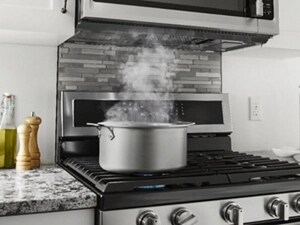 Pot of boiling water with rising steam on a gas stovetop