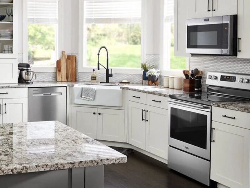 Maytag® electric range in white cabinetry below over-the-range microwave