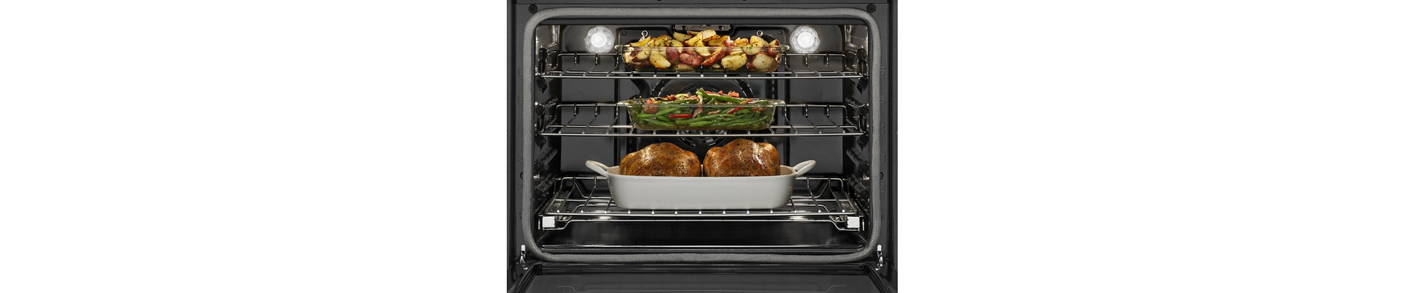 Various foods cooking in an oven on multiple racks