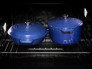 Two Dutch ovens inside an oven