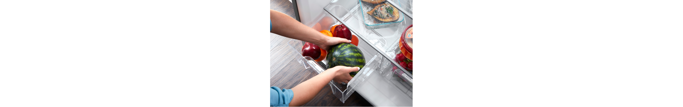 Person placing fruit in a refrigerator produce drawer