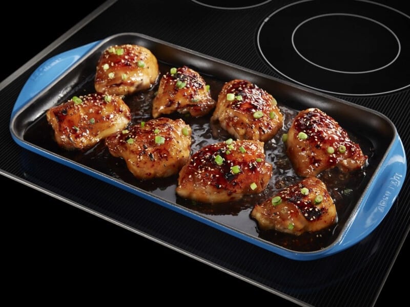 Chicken thighs in a pan on an electric cooktop