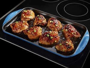 Chicken thighs in a pan on an electric cooktop