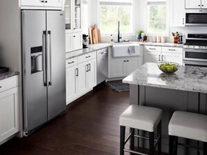 Counter-depth side-by-side refrigerator in kitchen with white cabinets