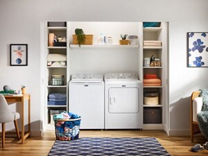 A white, top load washer and dryer pair in a laundry closet, surrounded by shelves