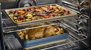 Turkey and sheet pan veggies cooking in an oven