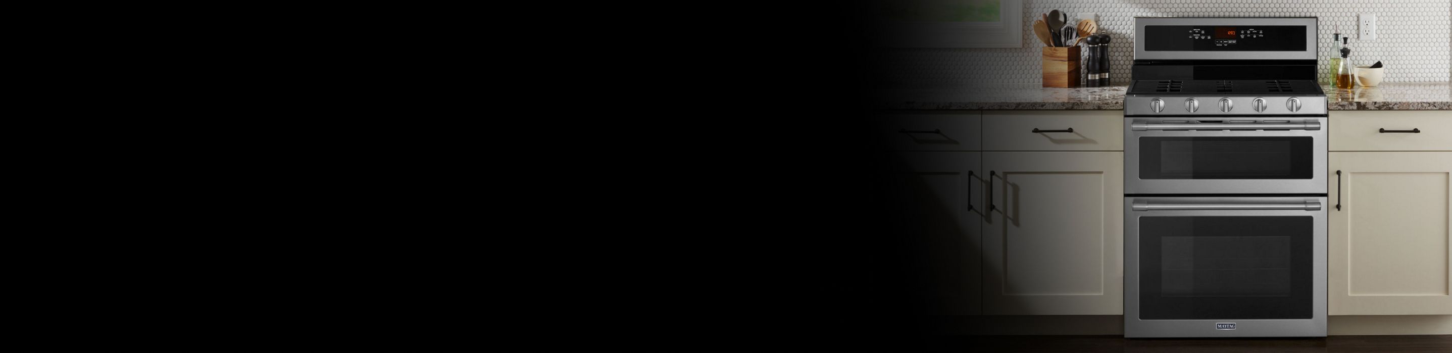 Black Maytag® gas range between countertops and cupboards