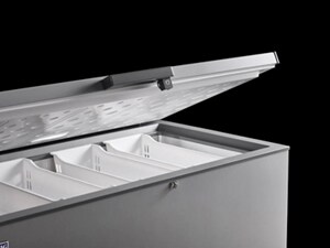 An empty chest freezer with the lid half open showing empty storage baskets