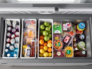 An open Maytag® chest freezer featuring Freezer-To-Fridge Convertibility, filled with refrigerator food
