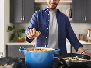 Person squeezing a lime into a pot of soup