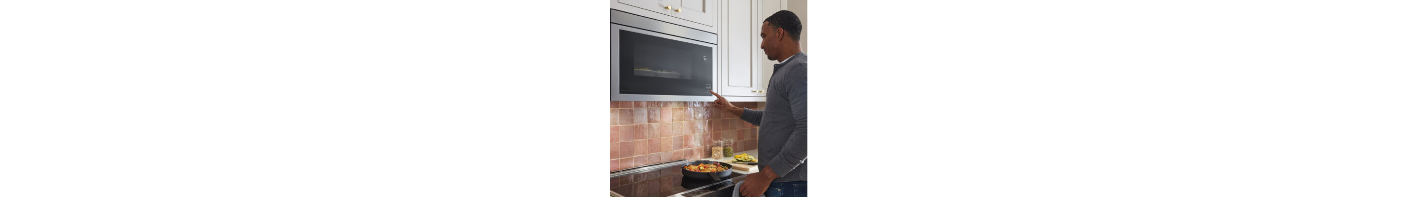 Person standing in front of an over-the-range microwave
