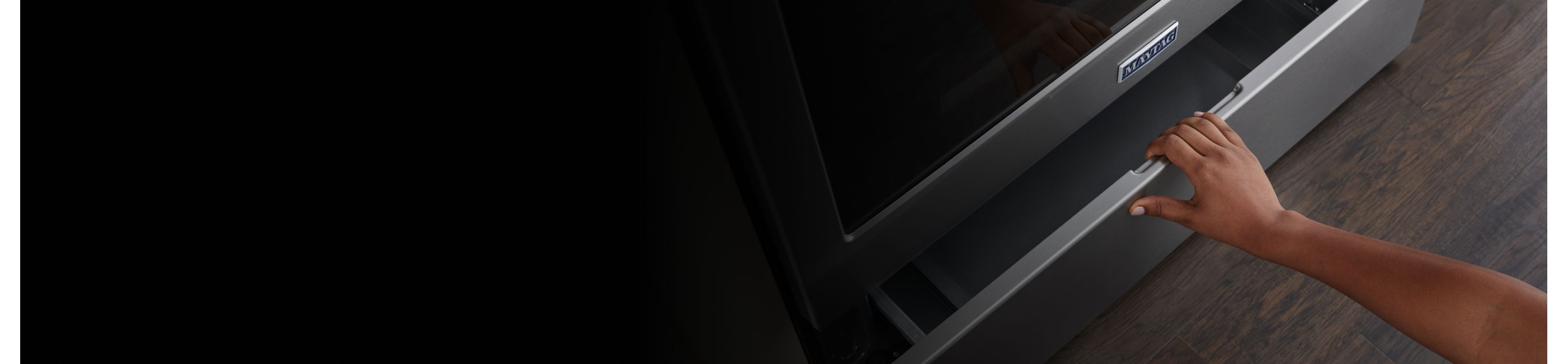 A person pulling open a Maytag® oven drawer