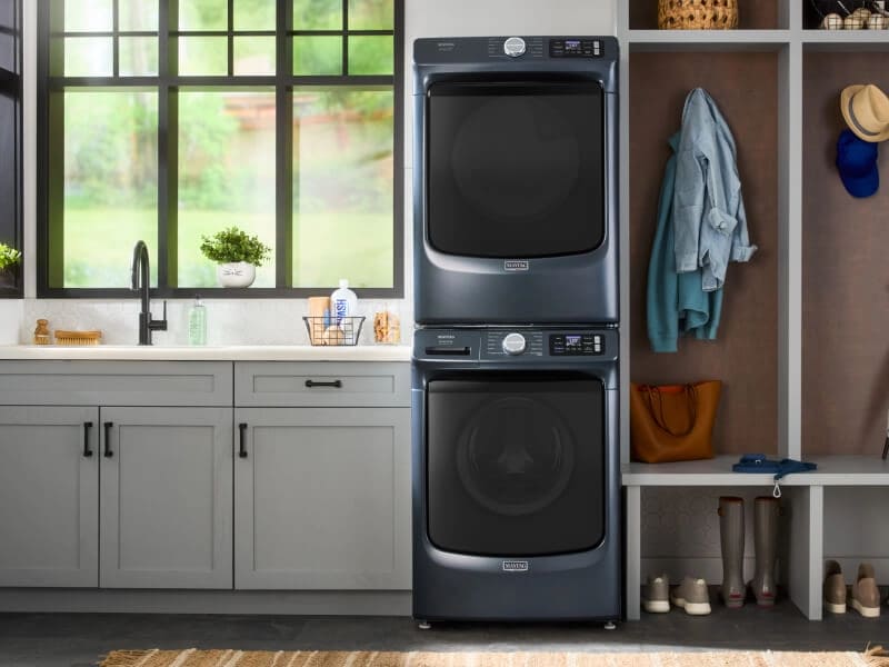 A stacked Maytag® washer and dryer set in a laundry area