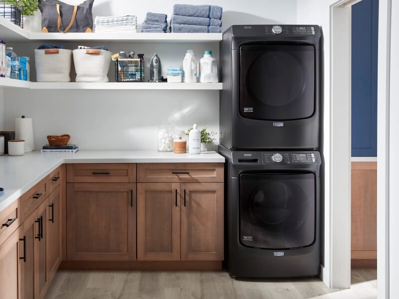 A laundry room with a stacked Maytag® washer and dryer