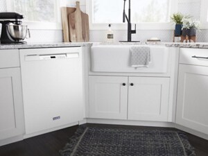 A white dishwasher surrounded by white cabinets and a white sink