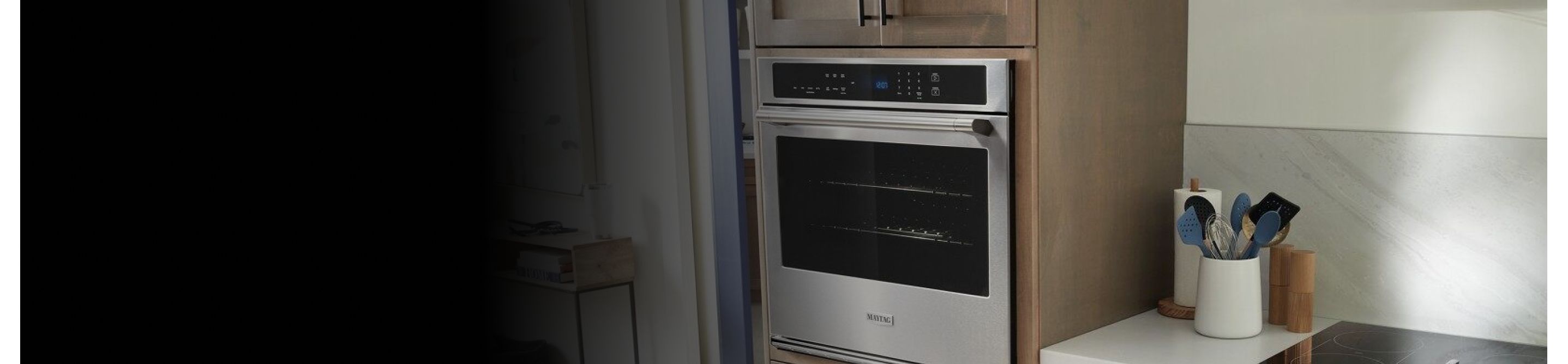 A Maytag® wall oven and a view of kitchen accessories on a countertop
