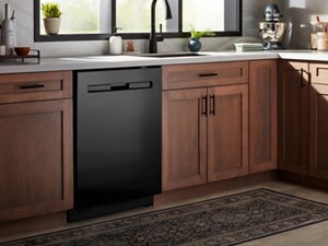 A black dishwasher surrounded by brown cabinetry