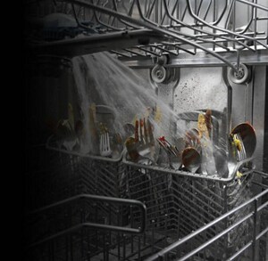 Dishes being sprayed with water on the inside of a dishwasher