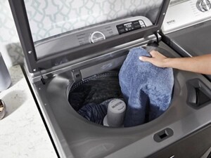 Person removing wet clothing from a washing machine