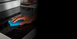 Person wiping down a ceramic cooktop