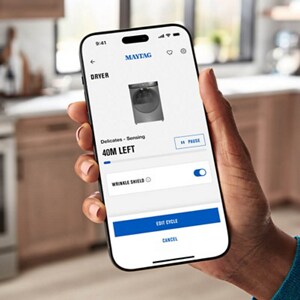 A hand holding a phone with the Maytag™ app screen