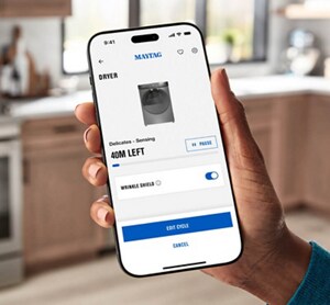 A hand holding a phone with the Maytag™ app screen