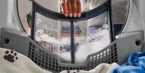 A hand pulling out a lint trap