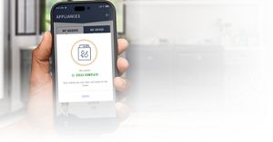 A hand holding a phone with the Maytag™ app screen