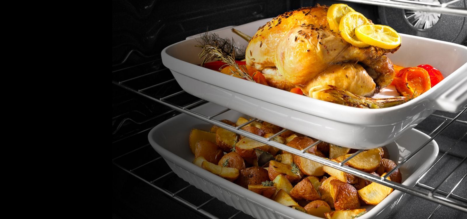 A roasted chicken on the top rack and potatoes on the bottom rack keeping warm.