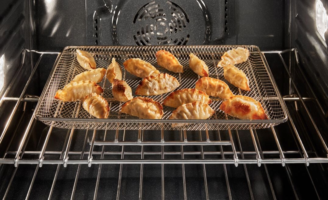 Food air frying in a Maytag® oven.