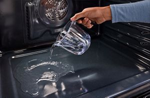 A person pouring a cup of water into a Maytag® oven.