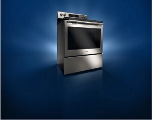 A stainless steel gas kitchen range against a black background.